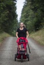 Female Jogger pushing her baby in a baby stroller while on a run Royalty Free Stock Photo