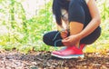 Female jogger tying her shoes in the woods Royalty Free Stock Photo