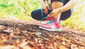 Female jogger tying her shoes in the woods Royalty Free Stock Photo