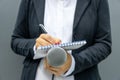 Female journalist at media event or news conference, writing notes, holding microphone Royalty Free Stock Photo