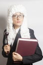 Female judge wearing a wig and Back mantle with eyeglasses holding judge gavel and book Royalty Free Stock Photo