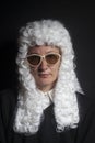 Female judge wearing a wig and black mantle with sunglasses Royalty Free Stock Photo