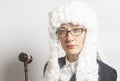 Female judge wearing wig and mantle with eyeglasses holding ju Royalty Free Stock Photo