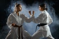 Female karate fighters, dark smoky background Royalty Free Stock Photo