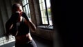 Female kickboxer is training in gym, striking and dodging from punches