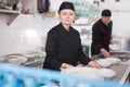 Female kitchen worker arranging cleaned dishes