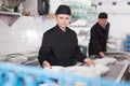 Female kitchen worker arranging cleaned dishes