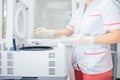 Female lab technician refills a centrifuge machine in the medical or scientific laboratory. DNA test. Science, chemistry, biology Royalty Free Stock Photo