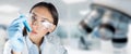 Female lab technician wearing glasses and gloves analyzes a test-tube in laboratory