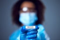 Female Lab Worker in Lab Coat And Face Mask Researching Omicron Variant Of Covid-19 Holds Test Tube Royalty Free Stock Photo