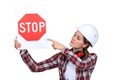 Female laborer pointing stop sign