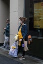 Female lady shopper with shopping bags wearing a face mask on the street