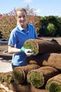 Female Landscape Gardener Laying Turf For New Lawn