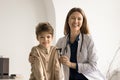 Female laryngologist doctor takes care of little boy in hospital