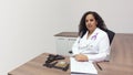 Female latin female doctor sitting with serious attitude in her office with stethoscope on her neck