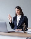 female lawyer conducts an online consultation from a laptop via video link for a client. work in a law firm checking