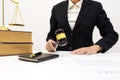 Female lawyer holding wooden dark gavel in office room.