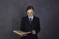 Female lawyer reads a big book with serious expression, woman in a man`s suit, tie and glasses