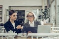 Female lawyer speaking with her secretary sitting in restaurant Royalty Free Stock Photo