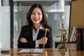 A female lawyer working with laptop, hammer in lawyer`s office with the goddess of justice with scales, advice, and concepts of ju Royalty Free Stock Photo