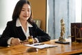 A female lawyer working with laptop, hammer in lawyer`s office with the goddess of justice with scales, advice, and concepts of ju Royalty Free Stock Photo