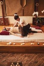 Woman using rocking technique on client during Thai massage Royalty Free Stock Photo