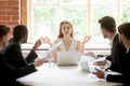 Female leader meditating ignoring angry coworkers Royalty Free Stock Photo