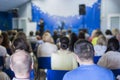 Female Lecturer Speaking In front of the Large Group of People