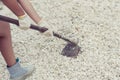 Female leg diggings stone for the cement with shovel. Royalty Free Stock Photo