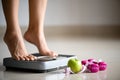 Female leg stepping on weigh scales with measuring tape, pink dumbbell and green apple. Healthy lifestyle, food and sport concept Royalty Free Stock Photo