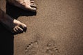 Female legs on a beach. Footprints visible on the sand