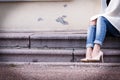 Female legs in a beautiful peach high-heeled shoes with gold nose. close-up. hands corrected jeans.