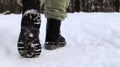 Female legs in black boots, winter walk in the snow. Active woman walking away from the camera in the winter forest. Focus on your Royalty Free Stock Photo