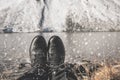 Female legs in black hiking boots against the background of snow mountains in Switzerland. Snow on women`s shoes Royalty Free Stock Photo