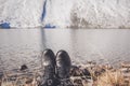 Female legs in black hiking boots against the background of snow mountains in Switzerland. Snow on women`s shoes Royalty Free Stock Photo