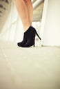 Female legs in black suede shoes with pavement in the