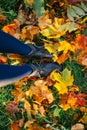 Female legs in boots on ground with autumn leaves Royalty Free Stock Photo