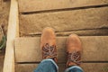 Female legs with boots on wooden steps with sand Royalty Free Stock Photo