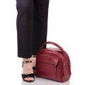 Female legs in classic black pants black lacquer shoes with red leather handbag in hand Royalty Free Stock Photo