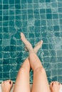 Female legs in a cold swimming pool shot from above