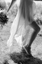 female legs in a dress. Boho style bride. Bridal bouquet. Livestyle
