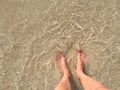 Female legs and feet in water on beach - vacation concept Royalty Free Stock Photo