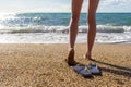 Female legs and flip-flops against sea landscape in summer evening at sunset. Beautiful woman walking along sea beach, relaxing at Royalty Free Stock Photo