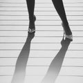 Female legs in golden shoes with high heels and shadow Royalty Free Stock Photo