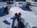 Female legs in hiking boots in snow on High Tatras mountains. Happy adventures in travel. Royalty Free Stock Photo