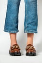 Female legs in jeans and brown casual leather shoes Royalty Free Stock Photo