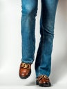 Female legs in jeans and brown casual leather shoes Royalty Free Stock Photo