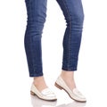 Female legs in jeans classic lacquer white shoes moccasins