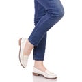 Female legs in jeans classic lacquer white shoes moccasins