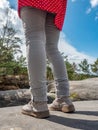 Female legs in lifght jeans and white leather boots  on mountain top Royalty Free Stock Photo